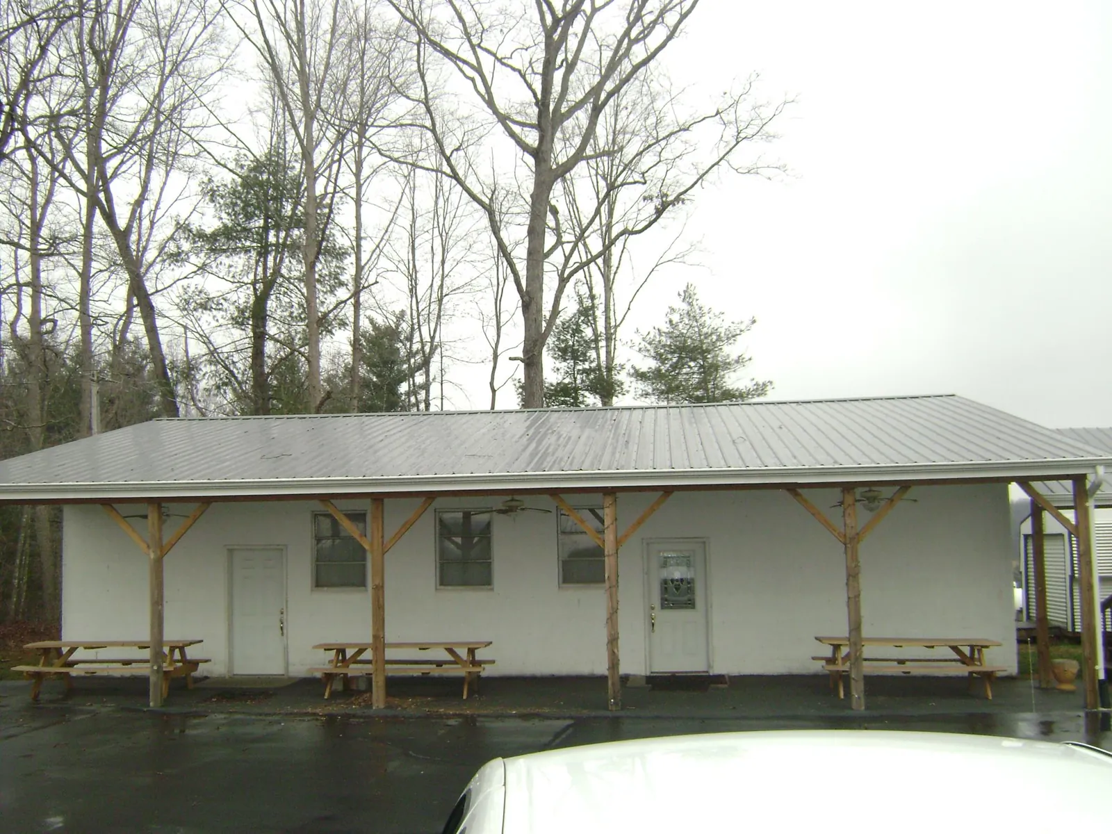 Gray metal roof over a block building with a timber post porch in Alton